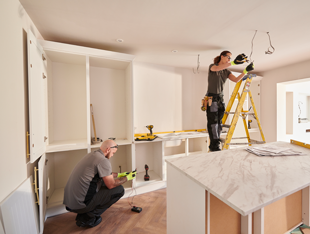 Woman on ladder replacing light fixture.